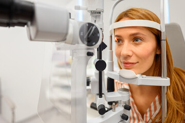 Female patient undergoing detailed eye examination with slit lamp light at ophthalmology clinic for vision assessment