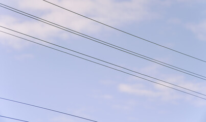 Cloudy sky with silhouetted cables
