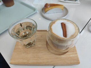 Glass of water and ้hot coffee on top cinnamon stick