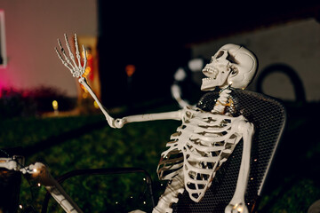 Night Halloween background. Halloween skeleton for decorated house. Scary decorated front yard of American house. Caricature or something. Halloween background. Autumn holiday of Halloween.