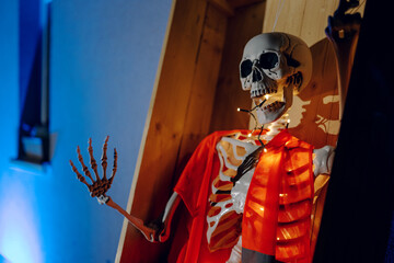 Night Halloween background. Halloween skeleton for decorated house. Scary decorated front yard of American house. Caricature or something. Halloween background. Autumn holiday of Halloween.