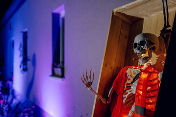 Night Halloween background. Halloween skeleton for decorated house. Scary decorated front yard of American house. Caricature or something. Halloween background. Autumn holiday of Halloween.
