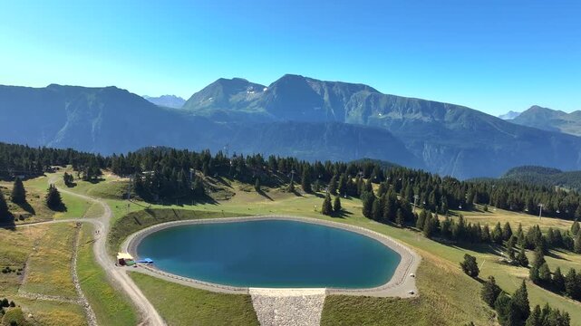 Aerial drone footage of the Chamrousse mountain resort and village located in the French Alps during summer. The video shows hotels, ski lifts, forested slopes