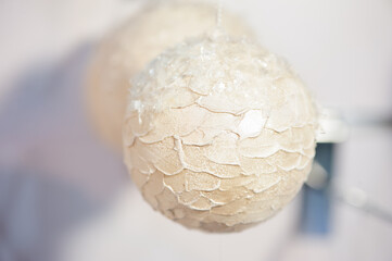 Hanging white ornament with cracked, flaked surface creates soft, tactile look. Ideal for winter holiday decor, Christmas, or themed crafts. Captures handmade, rustic elegance and festive charm