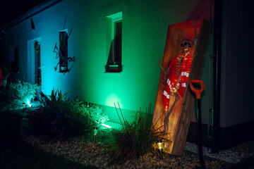 Night Halloween background. Halloween skeleton for decorated house. Scary decorated front yard of American house. Caricature or something. Halloween background. Autumn holiday of Halloween.