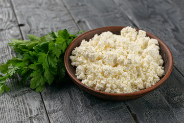Fresh Cottage Cheese in Rustic Bowl with Parsley on Wooden Table - Healthy Vegetarian Food Concept