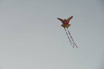 Butterfly shaped kite flying in the sky.