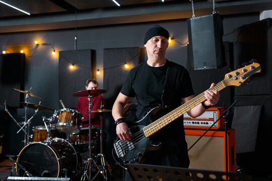 Musicians in a Studio Practicing With Bass Guitar and Drum Set