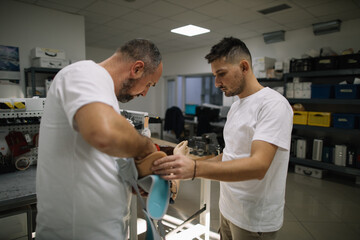 Coworkers working together on prosthetic arm adjustment