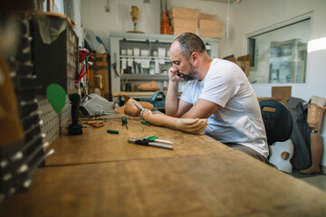 Technician speaking on the phone while working at the prosthetics lab