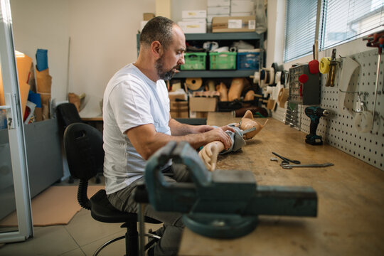 Orthopedic prosthetist assembling a prosthetic arm in workshop