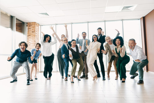 Cheerful business team celebrating success in a bright office space with teamwork, diversity, and collaboration spirit