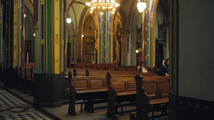 Blurred church interior with bokeh effect showcasing ornate architecture and wooden pews, conveying...