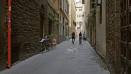 Narrow cobblestone alley with stone facades and parked bicycle, defocused bokeh alley; background copyspace backplate calm.