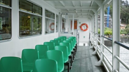 Fototapeta premium Ferry deck with rows of green plastic seats, defocused railings and distant lifebuoy interior; background backplate copyspace calm.