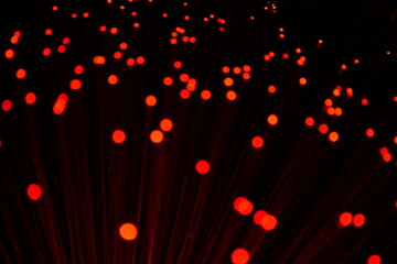 An abstract close-up of vibrant red fiber optic strands, suggesting data transmission and...