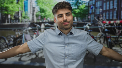 Fototapeta premium Man with bare arms extends arms on canal street; serenity.