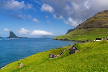 traditional wooden houses with grass roofs on the shores of the Sorvagsfjord in the Faroe Islands