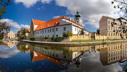 view of the historic Dominican monastery on the Malse River in downtown Ceske Budejovice with reflections and autumn colours