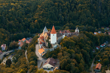 drone view of Krivoklat Castle in the Central Bohemian Region of the Czech Republic surrounded by colourful autumn forest © makasana photo