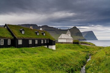 traditional sod-roof wooden houses and the historic church in Vidareidi on Vidoy in the Faroe Islands