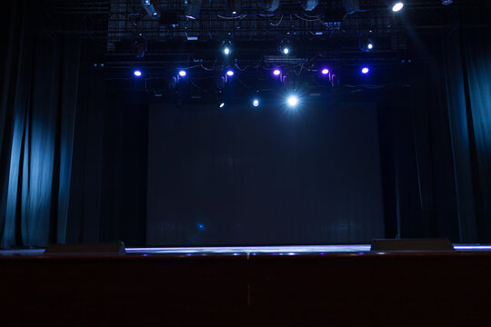 An empty stage of the theater, lit by spotlights and smoke before the performance