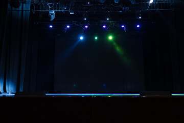 An empty stage of the theater, lit by spotlights and smoke before the performance