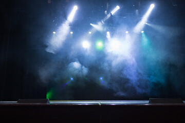 An empty stage of the theater, lit by spotlights and smoke before the performance