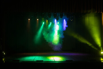 An empty stage of the theater, lit by spotlights and smoke before the performance