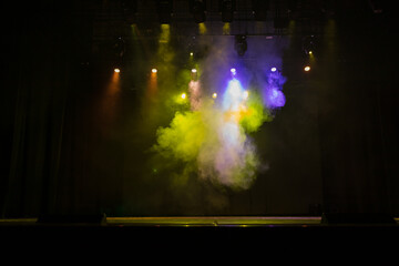 An empty stage of the theater, lit by spotlights and smoke before the performance