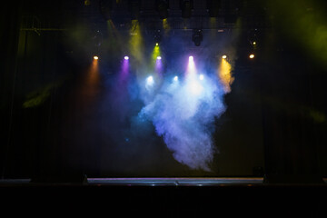 An empty stage of the theater, lit by spotlights and smoke before the performance