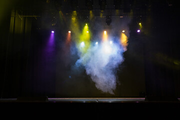 An empty stage of the theater, lit by spotlights and smoke before the performance