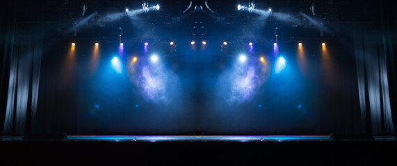 An empty stage of the theater, lit by spotlights and smoke before the performance