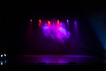 Spotlights in the concert hall. Stage light with colored spotlights and smoke.