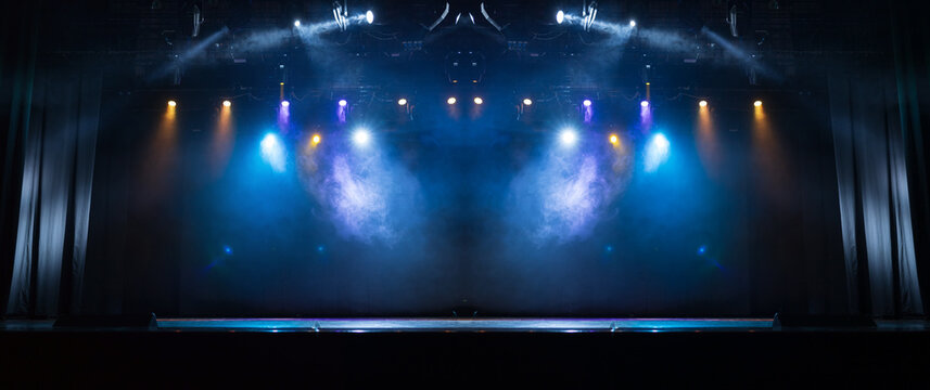 An empty stage of the theater, lit by spotlights and smoke before the performance