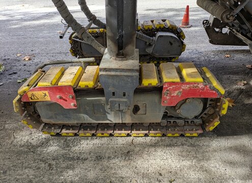 Vista de cerca de un soporte con ruedas con orugas de metal de una m&aacute;quina fresadora de asfalto 