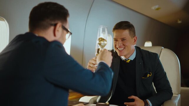 Successful business partners celebrating a profitable deal with a champagne toast while traveling together in a luxury private jet, enjoying a first-class flight and their wealthy lifestyle