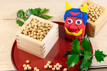 節分の豆まきの枡に入った大豆と赤鬼の面