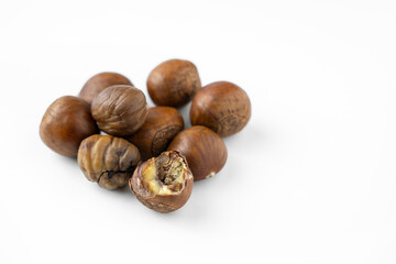 Close-up of fresh brown chestnuts isolated on white background, showing natural texture and detail....