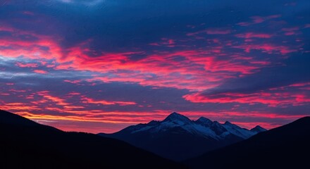 Majestic mountain range silhouettes under vibrant pink and blue cloudscape panorama view