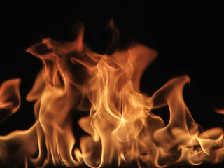 Vibrant, dynamic orange flames dance intensely against a deep, dark background creating a powerful, energetic visual.