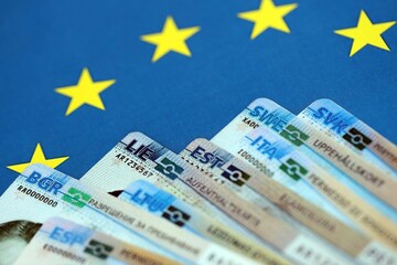 Permanent resident or residence permit cards lies on European Union flag. Paper specimen cards close up