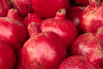 Ripe pomegranates close up, selective focus. Red pomegranate fruits on the market, natural background