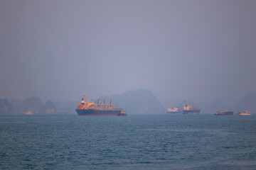 Halong bay seascape with cargo ships and limestone islands in Vietnam