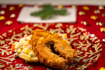 Fried carp and potato salad serving for Christmas dinner