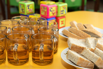 Tea served with bread alongside colorful building blocks on a bright table