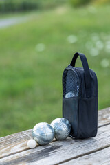 Petanque boules and jack with bag on wooden bench in Cuchery © Richard Semik