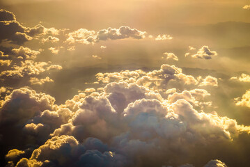 Golden sunset clouds viewed from airplane window, warm glowing sunlight, dramatic sky, soft texture, minimalistic aerial composition, peaceful atmosphere, travel and freedom feeling, dreamy light, nat