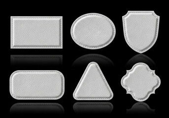 Six white leather patch shapes isolated on black background