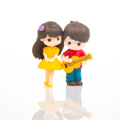Miniature couple playing ukulele and enjoying a cheerful moment together in a bright setting